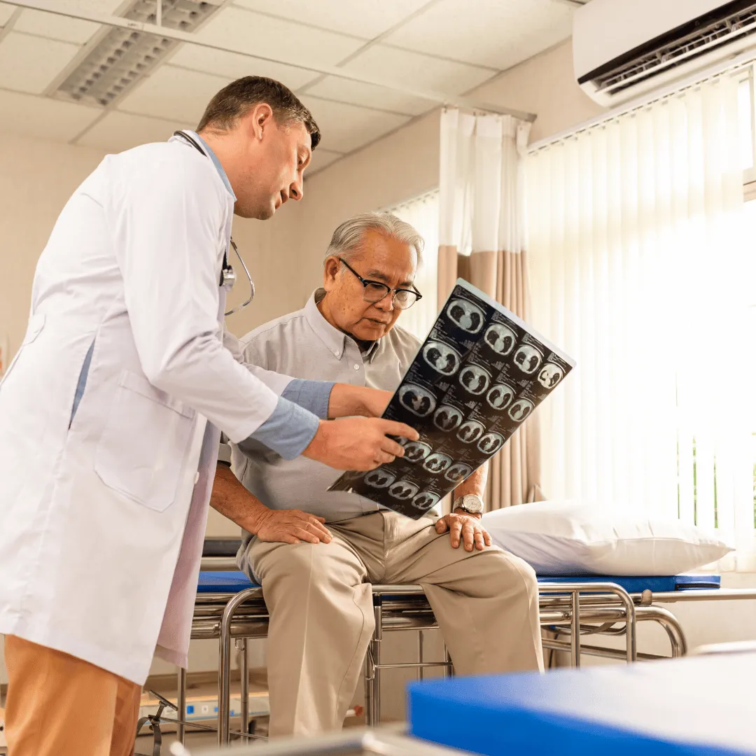 Profesional de la salud mostrando radiografía a paciente con movilidad reducida durante atención a domicilio